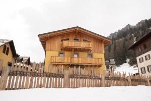 a building with a wooden fence in the snow at Alla Vecchia Dogana in Misurina