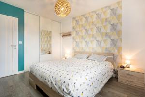 a bedroom with a large bed and a wall at Paradi Bleu in Trégunc
