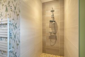 a shower with a shower head in a bathroom at Paradi Bleu in Trégunc +20 photos