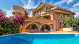 a house with a swimming pool in front of it at Sol y Montes in Fornalutx