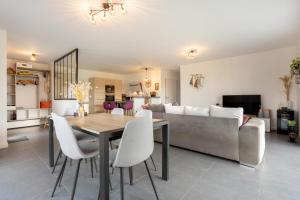 a dining room and living room with a table and a couch at Paradi Bleu in Trégunc