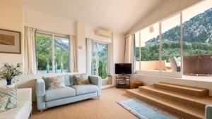 a living room with a couch and some windows at Sol y Montes in Fornalutx