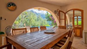 a dining room with a wooden table and a large window at Sol y Montes in Fornalutx