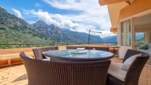 a patio with a table and chairs and mountains at Sol y Montes in Fornalutx