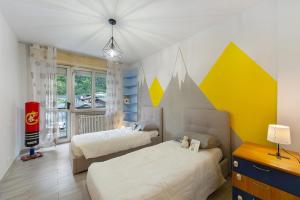 a bedroom with two beds and a room with yellow and white at Residenza Tambella in Verrès
