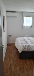 a white bedroom with a bed and a window at Balcons Du Soleil -Conciergerieland in Saint-Paul-lès-Dax