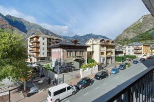 a city with cars parked on a street with buildings at Residenza Tambella in Verrès