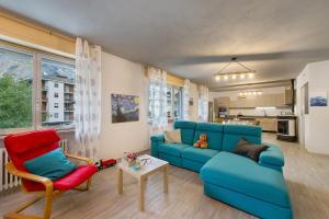 a living room with a blue couch and two chairs at Residenza Tambella in Verrès