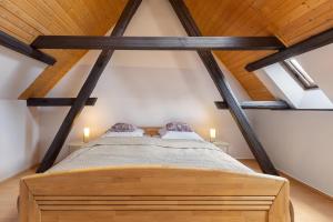 a bedroom with a wooden bed in a attic at Ferienwohnung an der Brigach in Donaueschingen