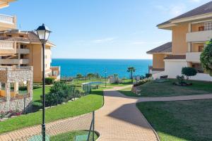 a walkway in front of a building with the ocean in the background at Modern penthouse in Fuengirola