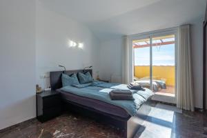 a bedroom with a bed and a large window at Modern penthouse in Fuengirola +18 photos