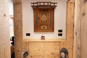 a room with a wooden cabinet with a clock on the wall at Alla Vecchia Dogana in Misurina +28 photos