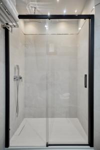 a shower with a glass door in a bathroom at Posada Sillería - Historic boutique Hotel in Toledo