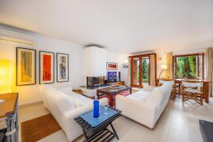 a living room with white chairs and a table at Casa en Centro Histórico Pollença in Pollença