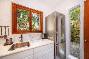 a kitchen with a sink and a refrigerator at Casa en Centro Histórico Pollença in Pollença +29 photos