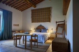 a bedroom with a bed and a table and chairs at Agriturismo Petra in Suvereto