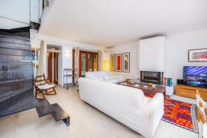 a living room with a white couch and a tv at Casa en Centro Histórico Pollença in Pollença