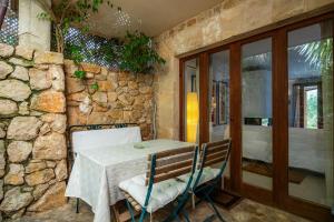 a table and chairs in a room with a stone wall at Casa en Centro Histórico Pollença in Pollença