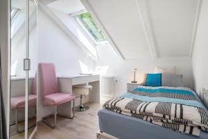 ein Schlafzimmer mit einem Bett und einem rosa Stuhl in der Unterkunft Fewo Siebert in Eichbühl