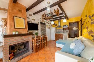 a living room with a fireplace and a kitchen at La Casa Al Revés in Laroya