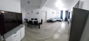 a living room with a table and chairs and a couch at Apart Alex in Constanţa +2 photos
