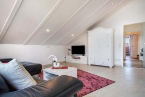 ein Wohnzimmer mit Sofa und Fernseher in der Unterkunft Fewo Siebert in Eichbühl