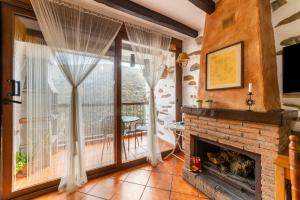 a living room with a fireplace and a large window at La Casa Al Revés in Laroya