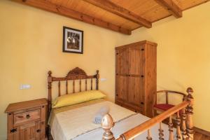 a bedroom with a wooden bed and a wooden cabinet at El Alarife in Sediles