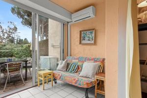 a living room with a couch on a patio at Studio Saint Clair pieds dans l'eau in Le Lavandou