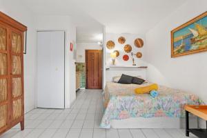 a bedroom with a bed and a painting on the wall at Studio Saint Clair pieds dans l'eau in Le Lavandou +15 photos