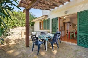a patio with a table and chairs and a house at Hause Sant'Ilario in Campo nell'Elba