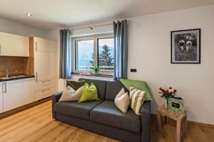 a living room with a couch and a kitchen at Ferienwohnung am Mühlbachl in Rohrberg