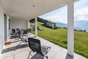 a patio with chairs and a view of a house at Ferienwohnung am Mühlbachl in Rohrberg