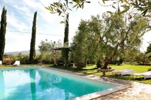 a swimming pool in a garden with trees at Il Gaggiolo 2 in Grosseto