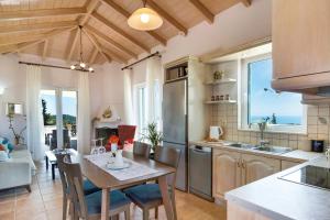a kitchen and dining room with a table and chairs at Villa Belvedere Rosa in Lefkada