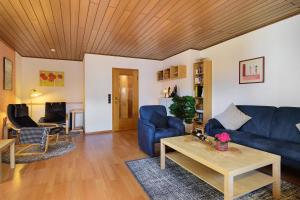 a living room with a blue couch and a table at Eifelferienhaus Thome Lissendorf in Lissendorf