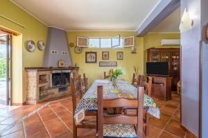 a dining room with a table and a fireplace at Villa Raffa in Avola