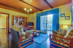 a living room with chairs and a table and a television at Villa Morera in Arafo