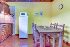 a kitchen with a wooden table and a white refrigerator at Villa Morera in Arafo