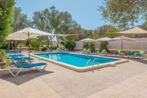 a swimming pool with lounge chairs and umbrellas at Els Marsals in Llucmajor