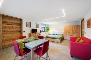 a living room with a table and chairs and a bed at La Pièce de Leo in Châtillon