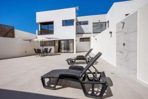 a patio with black chairs on a white building at Las Cuestitas Sol in Pájara