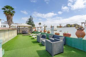 an outdoor patio with grass and chairs on a roof at Casa Rústica San Francisco 1 in Telde