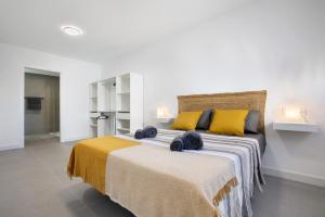 a bedroom with a large bed with yellow pillows at Las Cuestitas Sol in Pájara