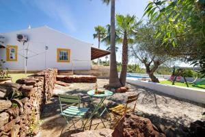 a patio with a table and chairs next to a house at Casa Noah in São Bartolomeu de Messines