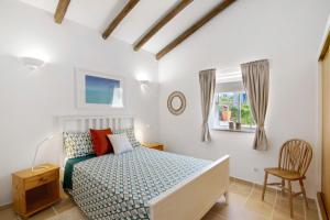 a white bedroom with a bed and a window at Casa Noah in São Bartolomeu de Messines +20 photos