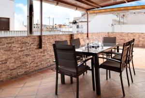 a table with chairs and wine glasses on a patio at Casa Unifamiliar Rio Barbate in Barbate