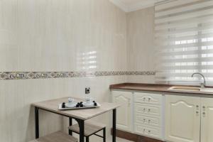 a white kitchen with a table and a sink at Casa Unifamiliar Rio Barbate in Barbate