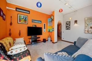 a living room with orange walls and a tv at Ca dei Tati -Citr 1181 with Jacuzzi in Imperia