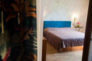 a bedroom with a bed with a blue head board at Casa di Olly in Sona